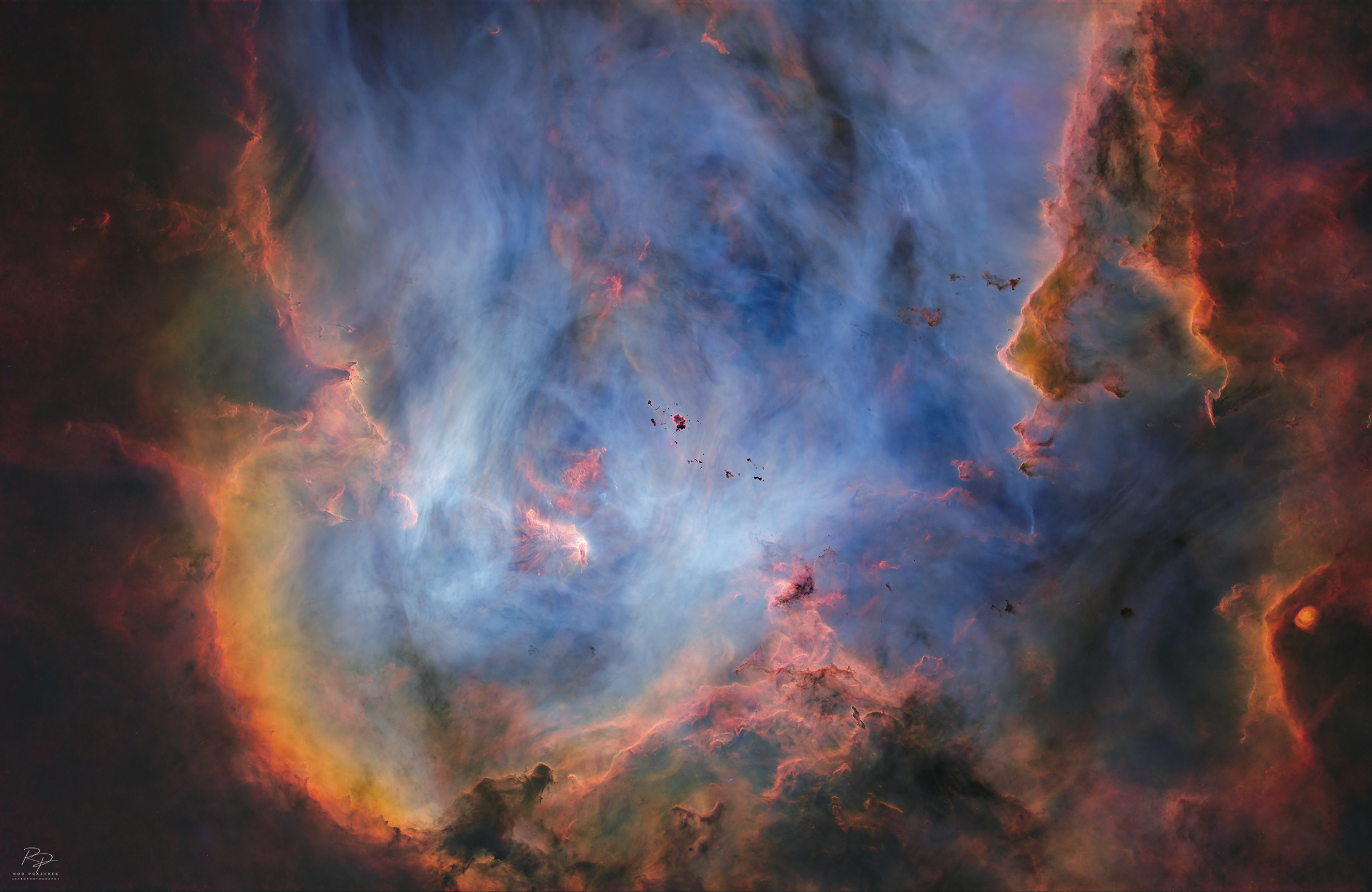 Shown is the deep region of the nebula, rich in gas surrounded by colorful stars and dense filaments of dark dust.