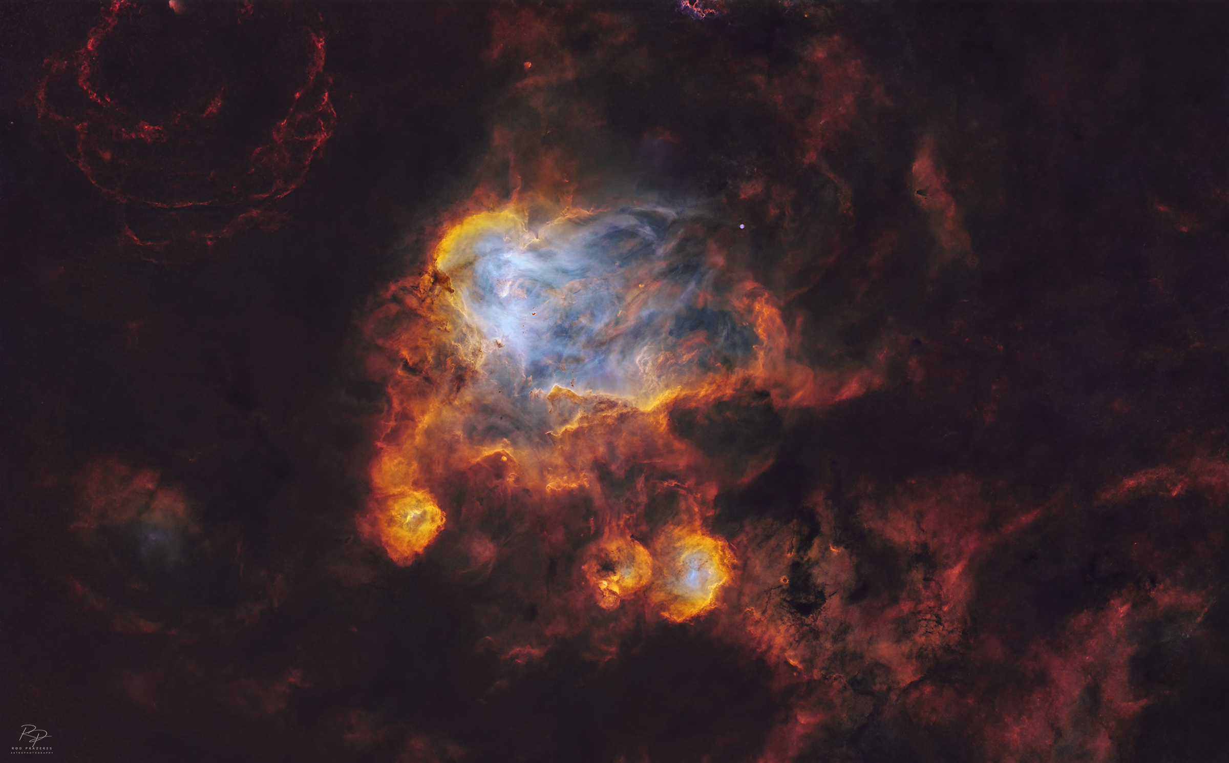 Shown is the deep region of the nebula, rich in gas surrounded by colorful stars and dense filaments of dark dust.