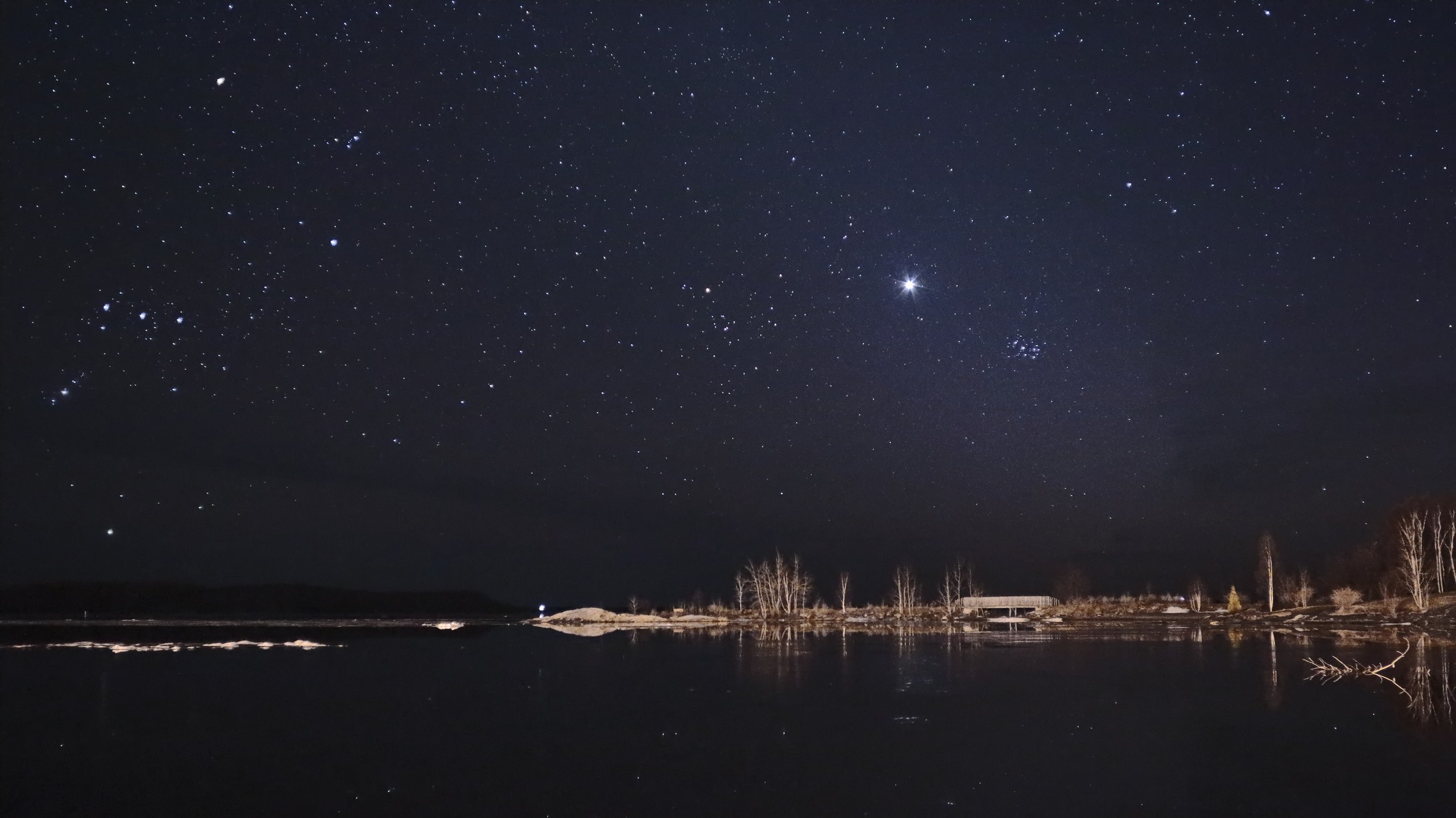 starry night above the lake where Venus shines brightly near the Pleiades constellation