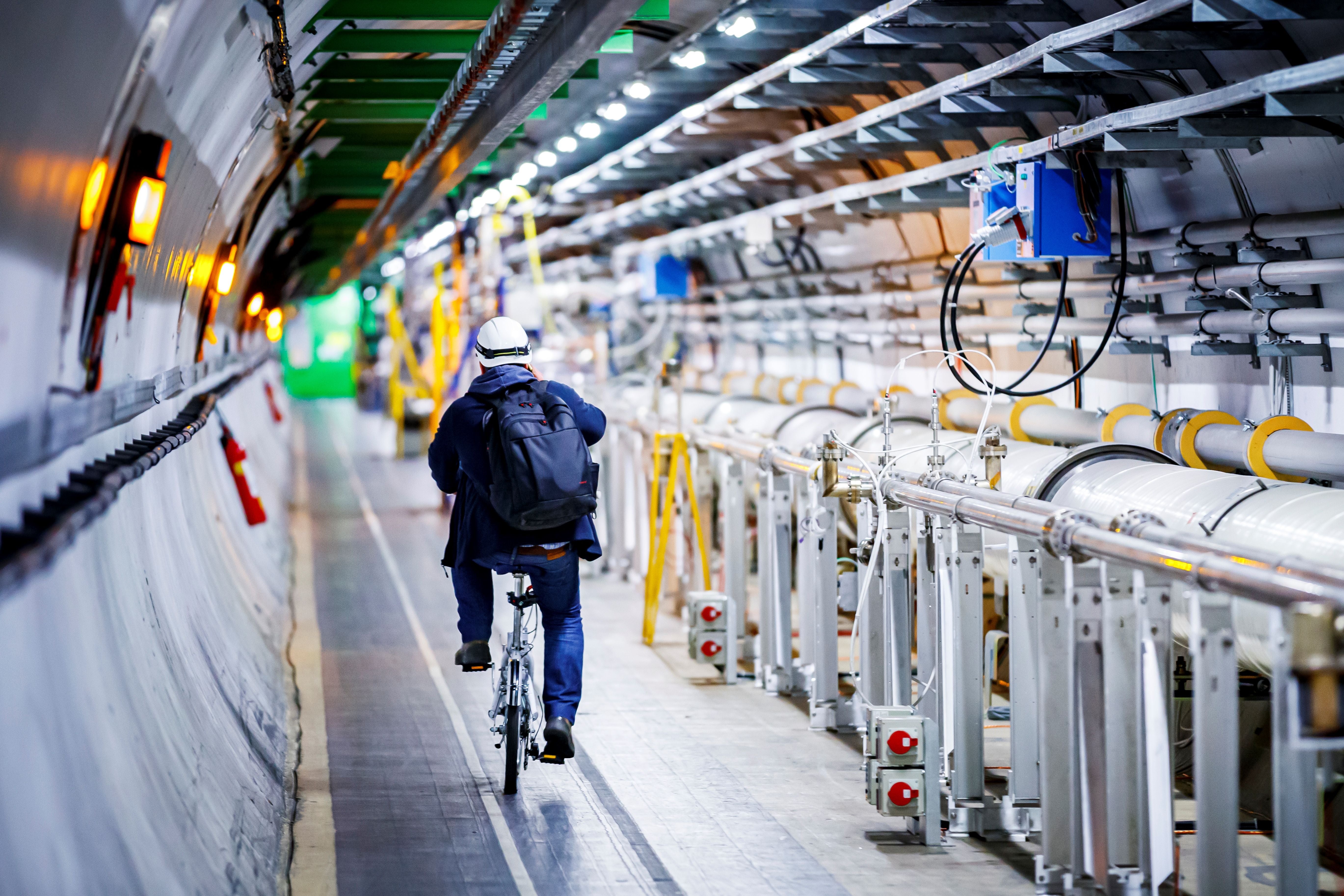 A man rides his bicycle near the underground Large Hadron Collider during a break in 2020.