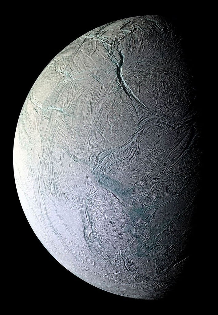 An ice-covered moon with cracks and a frozen surface. Enceladus.