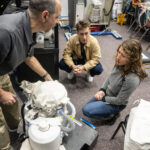 NASA astronaut Christina Koch works on an experimental version of the Orion space probe.